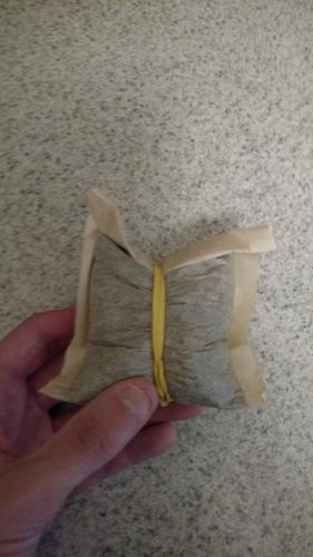 Tea bag sealed into a packet with an elastic band.