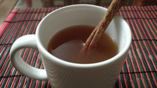 Mug of mulled apple cider, including cinnamon stick.